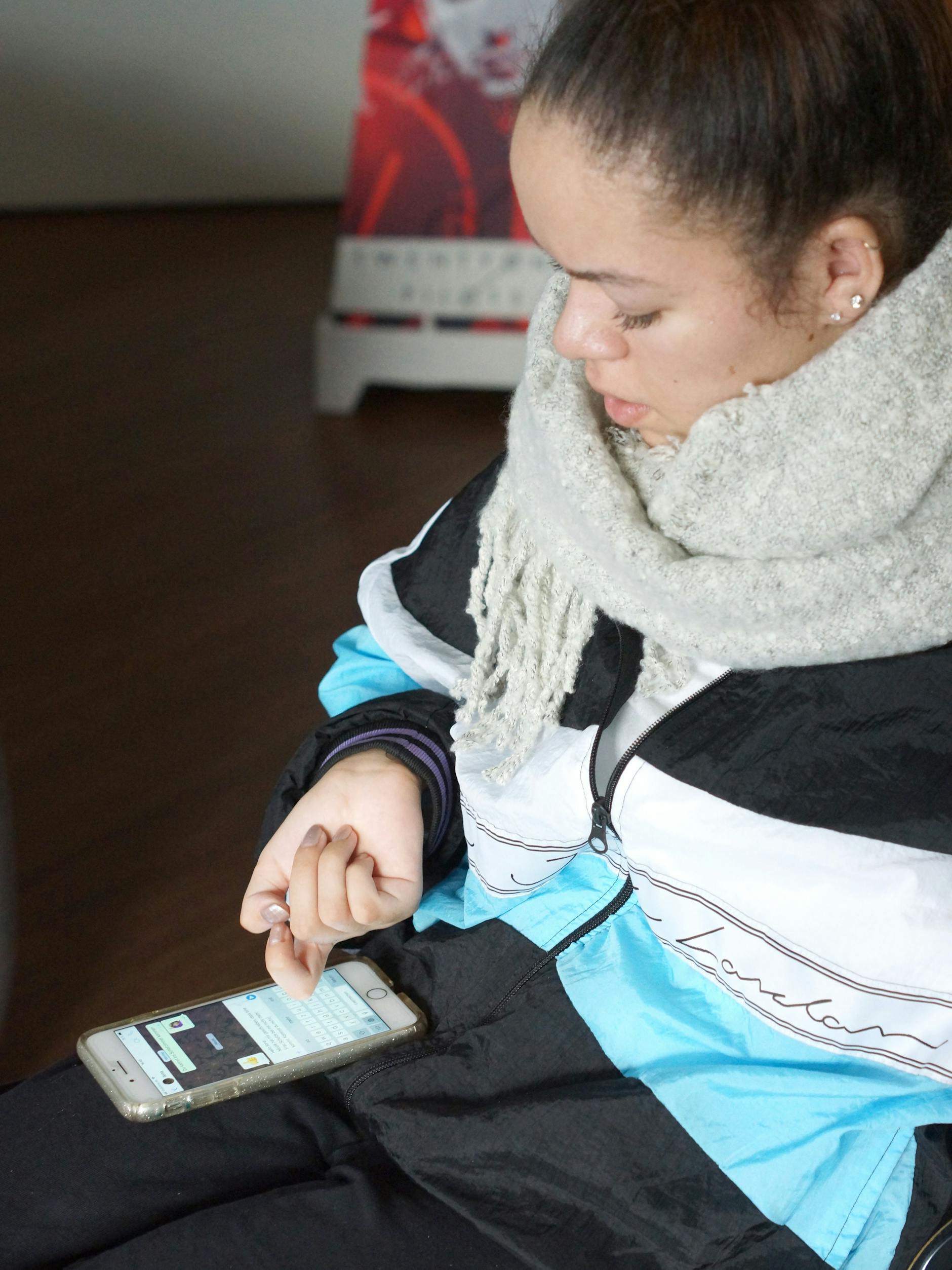 Auf ihrem Handy tippt Elisa Chirino mit dem Fingerknöchel. 