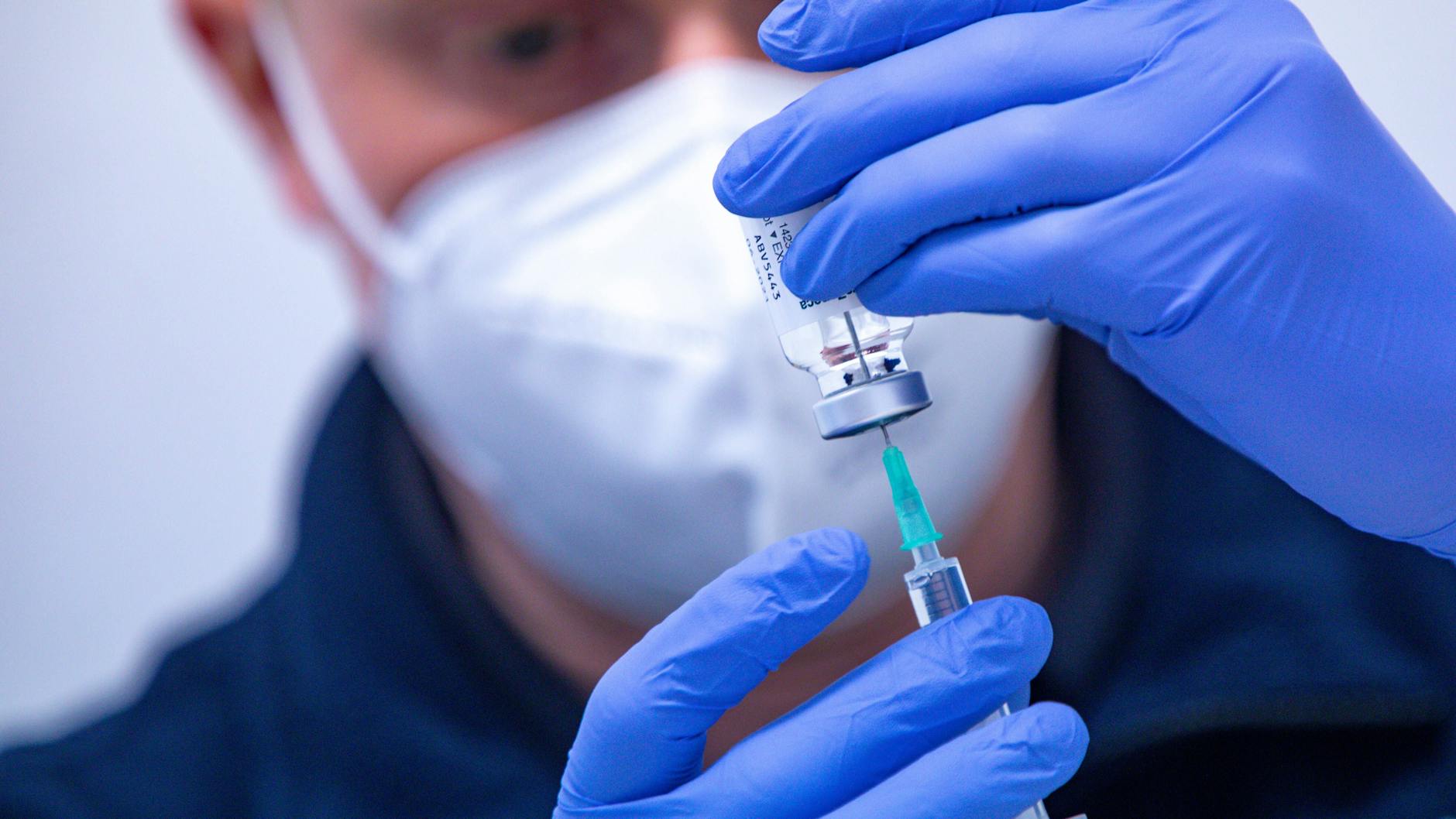 Ein Mitarbeiter eines Gesundheitsteams bereitet eine Corona-Impfspritze vor.