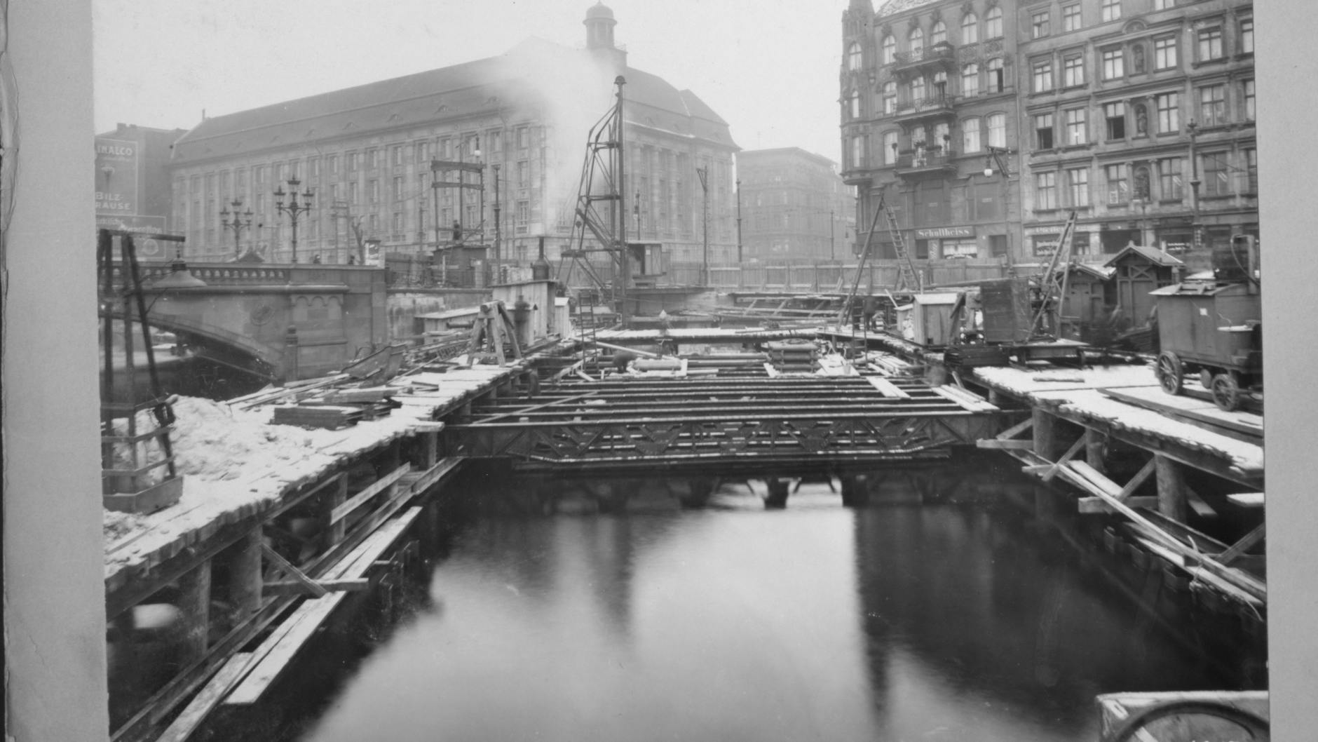 Ein Bild von den Bauarbeiten. Der Blick nach Norden zeigt den Bereich zwischen den Spundwänden, in dem der U-Bahn-Tunnel entsteht. Links ist die Waisenbrücke zu sehen, die 1945 beschädigt und 1960 abgebrochen wurde.