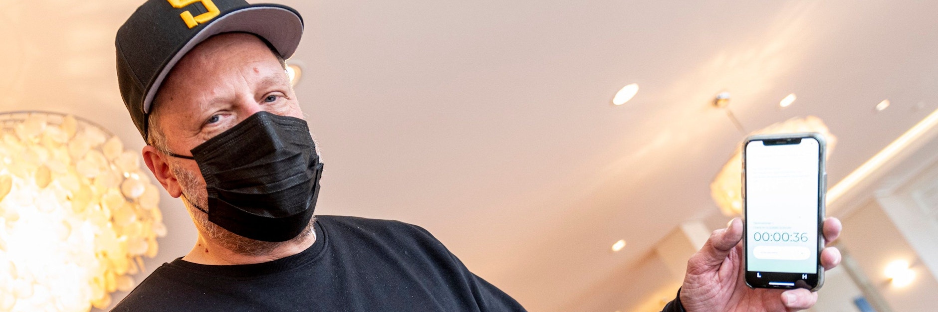 Rapper Smudo demonstriert auf seinem Smartphone die App Luca. 