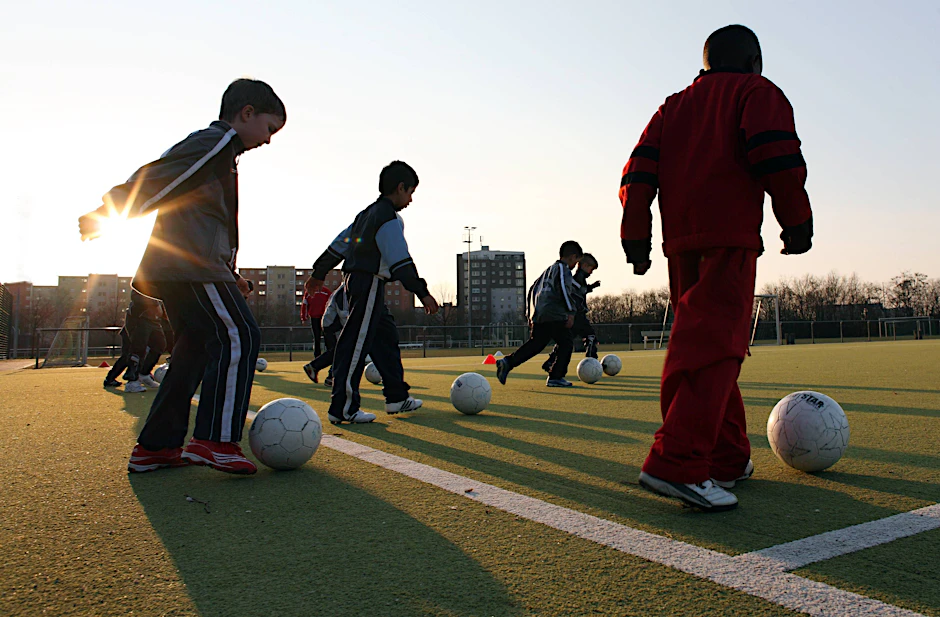 Ein Motiv aus einer anderen Zeit: Kinder, die gemeinsam Fußball spielen.
