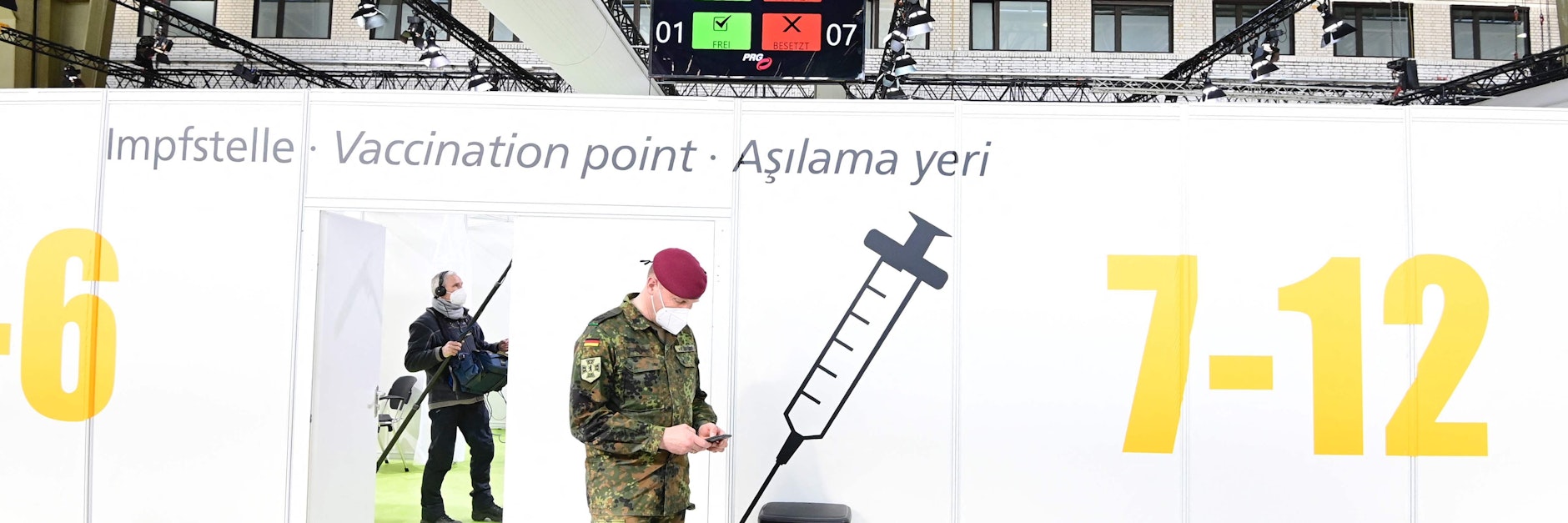 Ein Soldat blickt im am Montag im Tempelhofer Flughafen-Hangar 4 eröffneten Impfzentrum auf sein Handy.