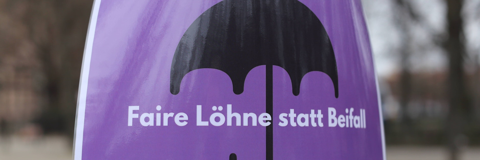 Das Plakat, bei&nbsp; einer feministischen Demo gezeigt, weist auf die unterschiedliche Entlohnung von Männern und Frauen hin.