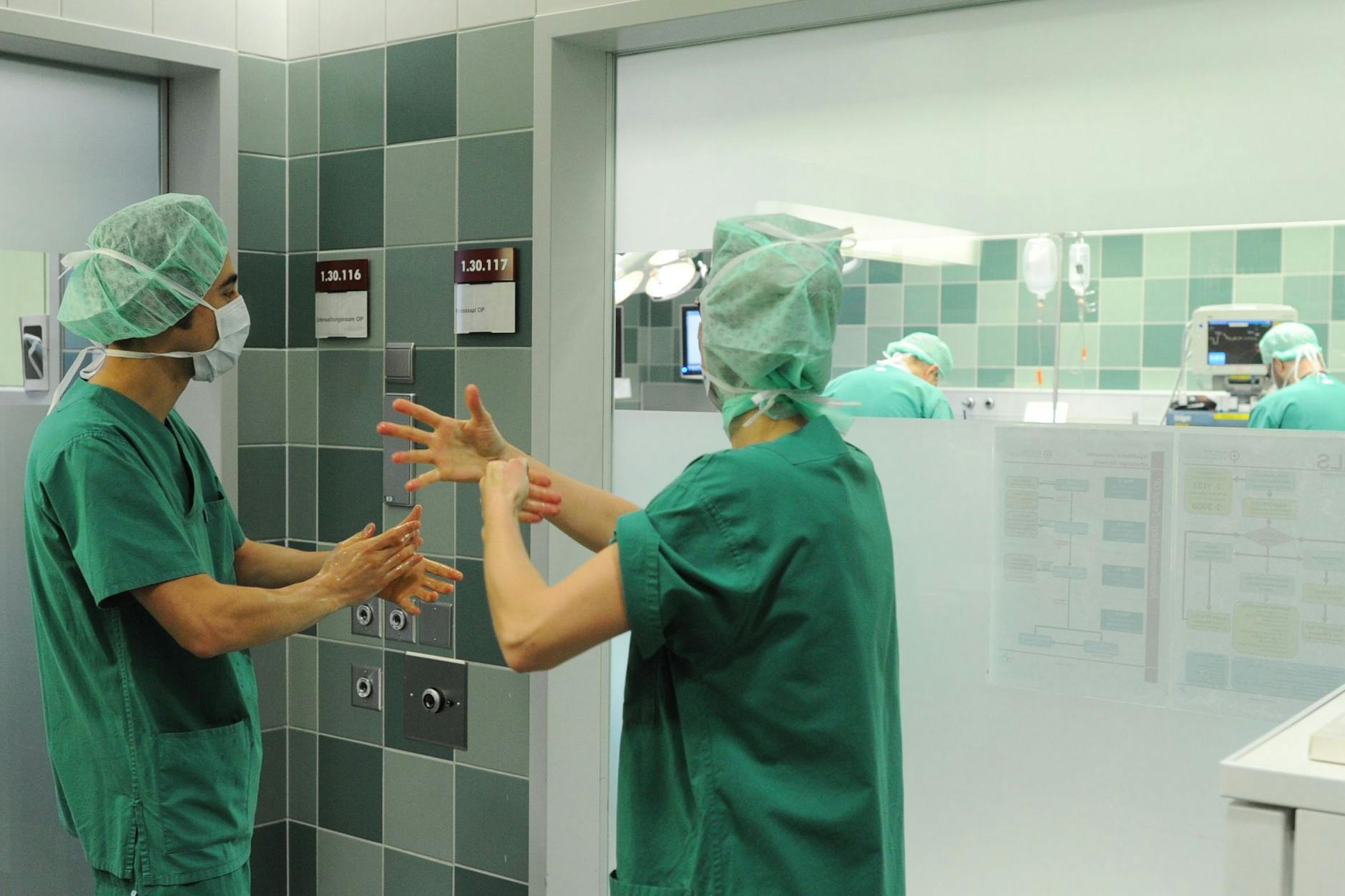 Operateure desinfizieren ihre Hände. Deutschland und die Niederlande gehen bei der Klinikhygiene verschiedene Wege. 