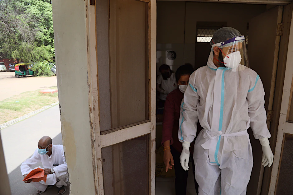 Neu Delhi: Ein Gesundheitsarbeiter bereitet sich darauf vor, wartende Menschen auf das Coronavirus zu testen.