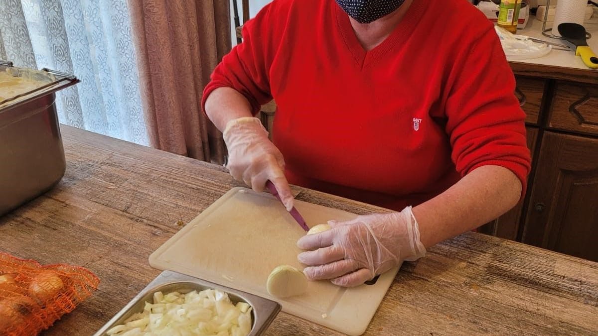 April 2021: Michaela Trottner schneidet die Zwiebeln für das Menü.