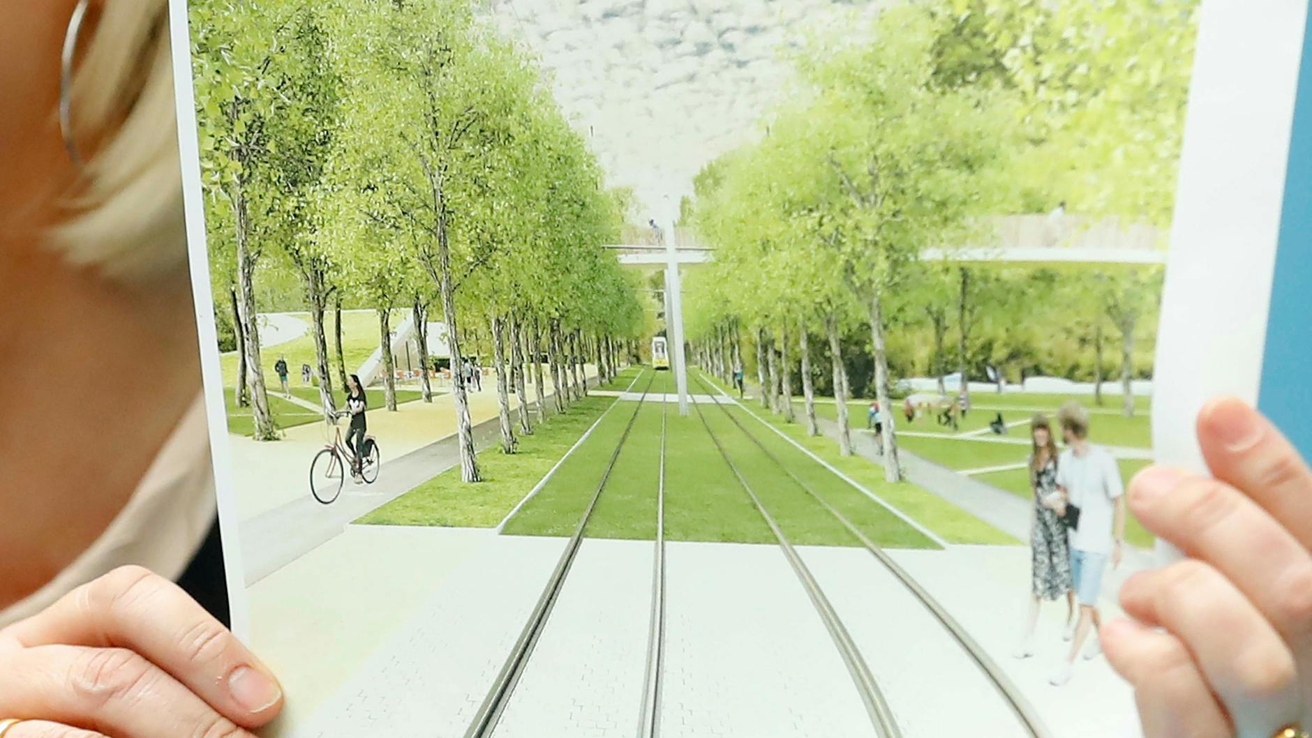 Transport minister Regine Günther holding up the plans for the tram in Görli.