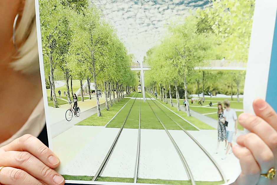 Transport minister Regine Günther holding up the plans for the tram in Görli.