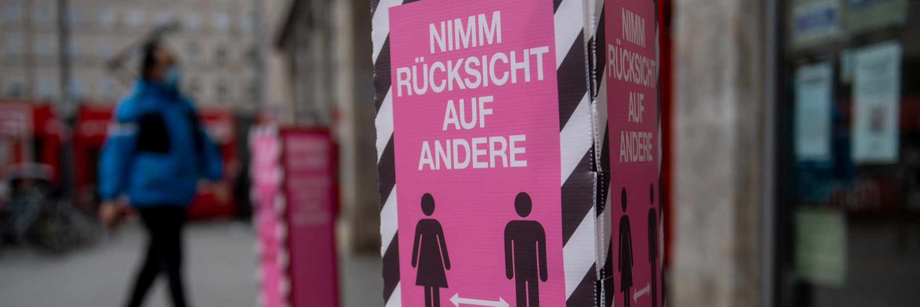 „Nimm Rücksicht auf andere - halte Abstand“ steht auf einem Schild vor dem Eingang zu einem Modegeschäft in Halle/Saale. Die Politik ringt um eine bundesweite Corona-Notbremse. 