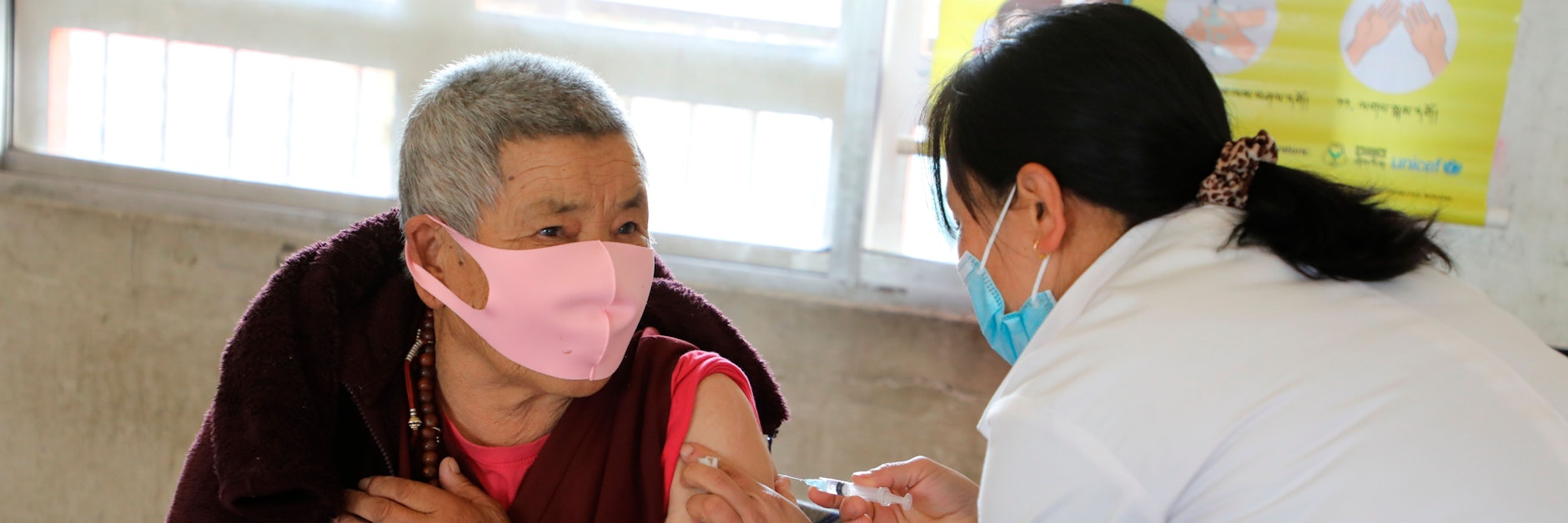 Ein älterer Mann in Bhutan bekommt eine eine Corona-Impfung verabreicht.