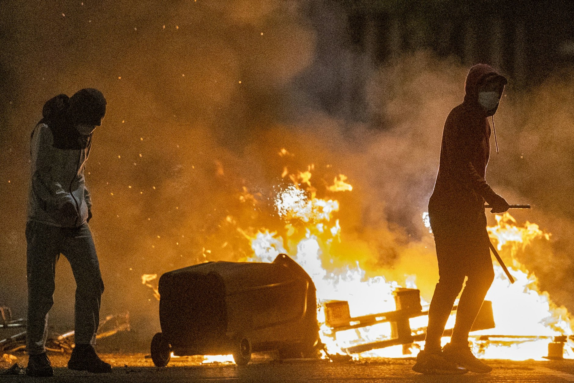 Menschen stehen während weiterer Unruhen neben einem Feuer in einer Straße in Belfast. In der britischen Provinz Nordirland kommt es seit Tagen zu nächtlichen Krawallen.