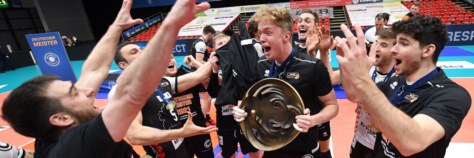 Volleyballfeier: Während Pierre Pujol (vorne links) die Party dirigiert, stemmt Anton Brehme die Meisterschale. Auf der Rückfahrt entpuppt sich Tim Carlé (r.) als bester Sänger.