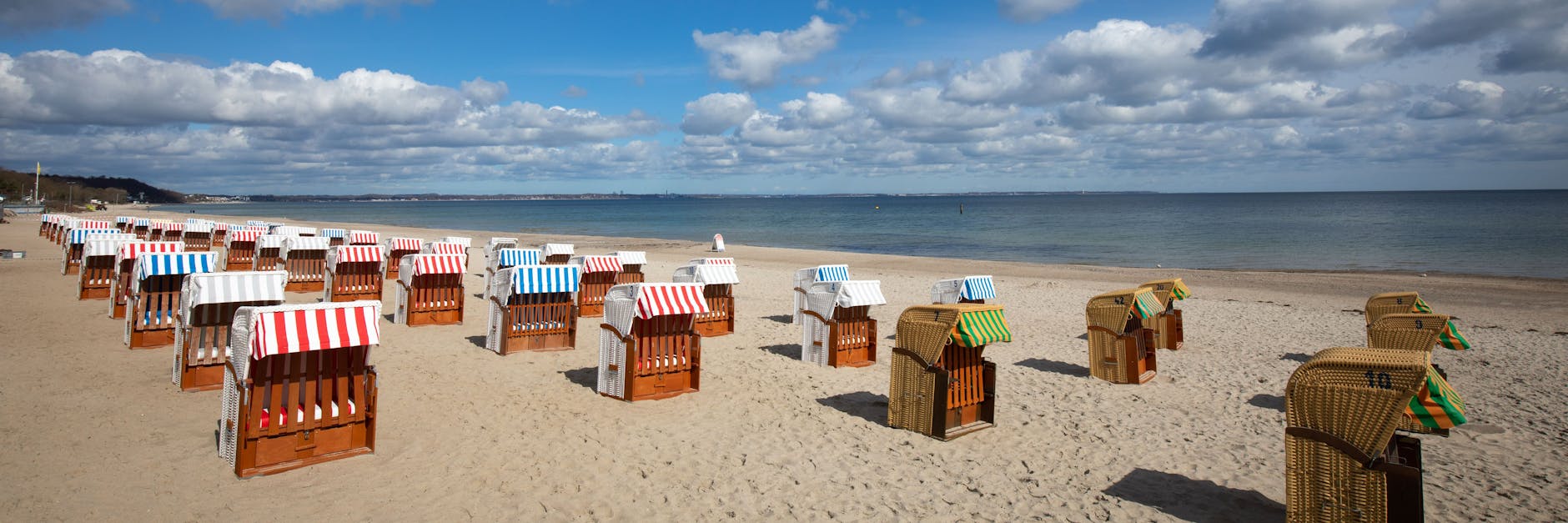 Geschlossene Strandkörbe stehen auf dem fast menschenleeren Strand an der Ostsee. F