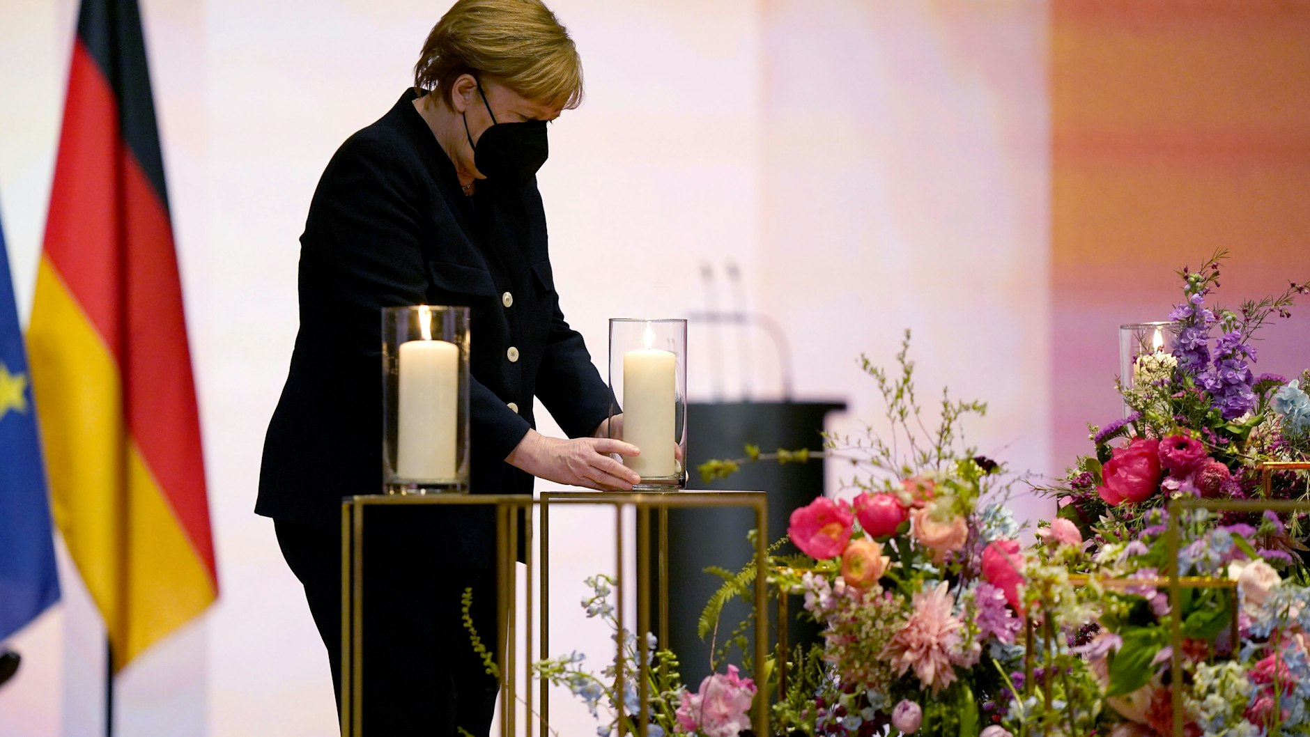 Kanzlerin Angela Merkel (CDU) hält eine Kerze während der zentralen Gedenkfeier im Konzerthaus am Gendarmenmarkt.