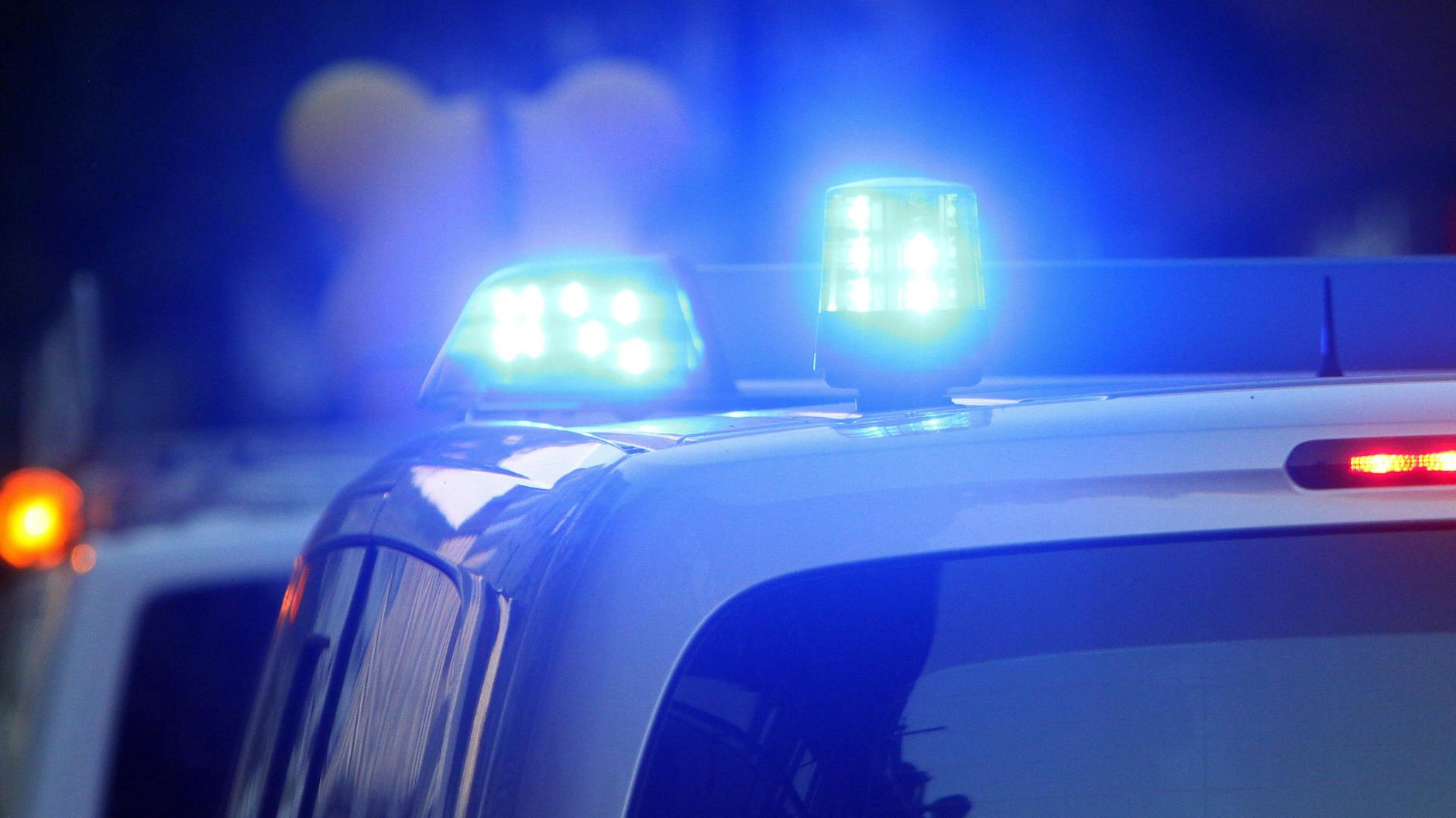 Einsatzwagen der Polizei stehen mit Blaulicht an einem Tatort (Symbolbild). 