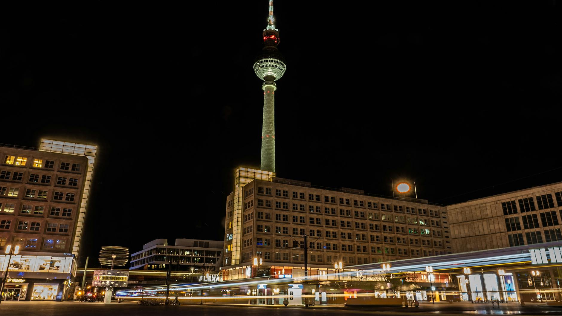 Straßenbahnen fahren über den Alexanderplatz. Sollte im Rahmen der Covid-Maßnahmen eine Ausgangssperre verhängt werden, dürfen Passanten zu gewissen Zeiten ohne Grund nicht mehr unterwegs sein. 