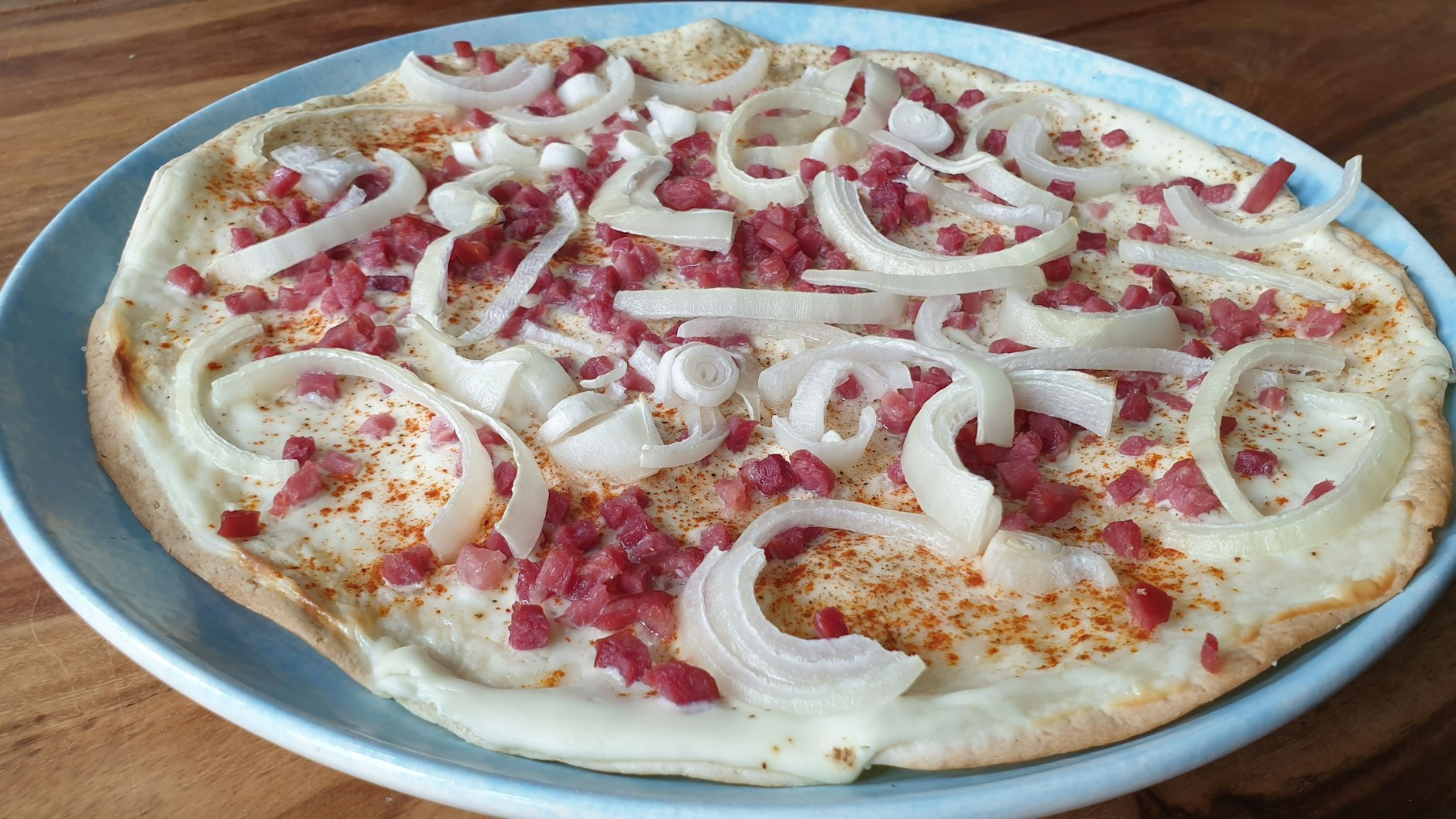 Wer es mag, kann den Blitz-Flammkuchen zusätzlich mit Paprikapulver würzen. 
