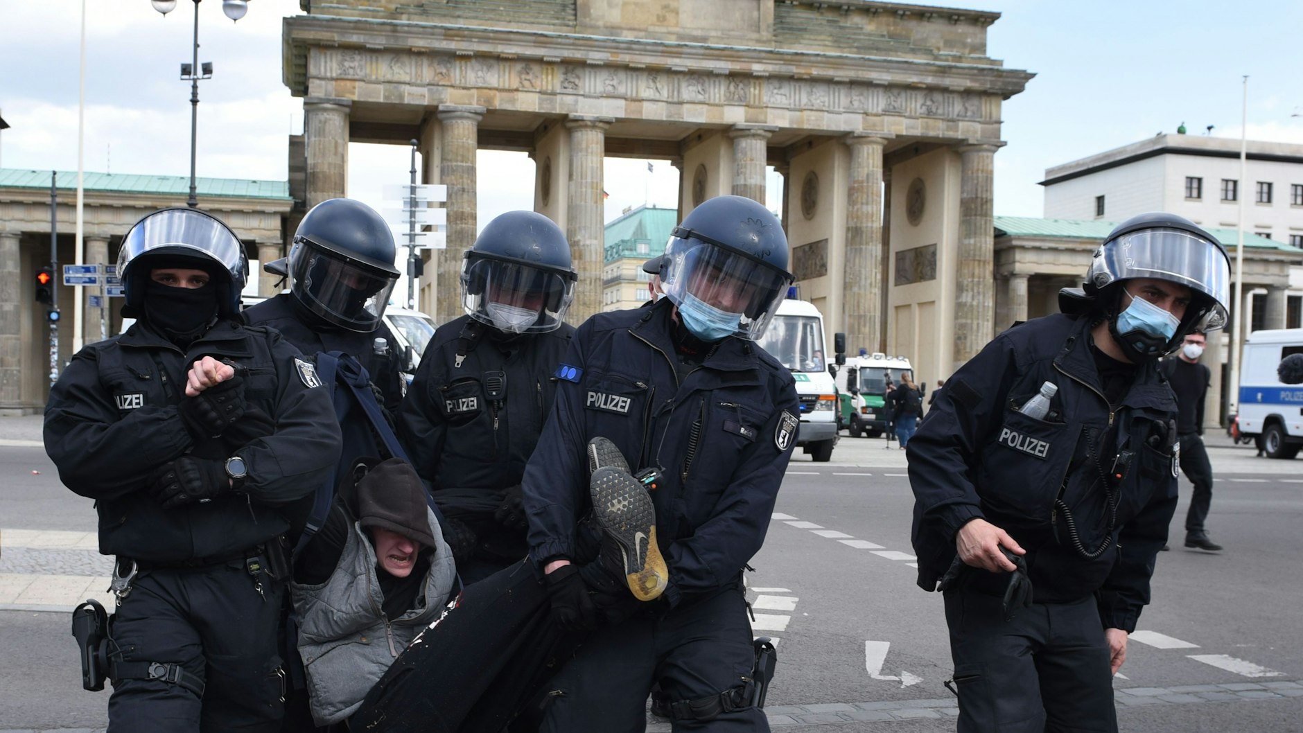 Polizisten nehmen einen Demonstranten fest.<br><br>