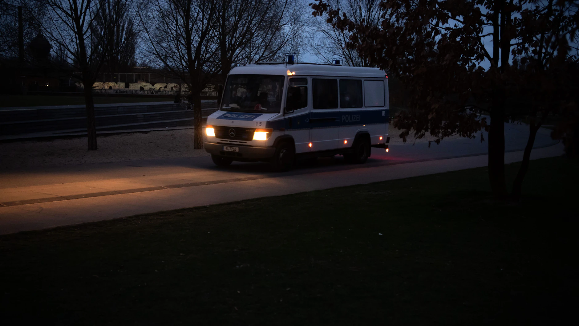 Ein Polizeiwagen fährt durch den Park am Gleisdreieck.