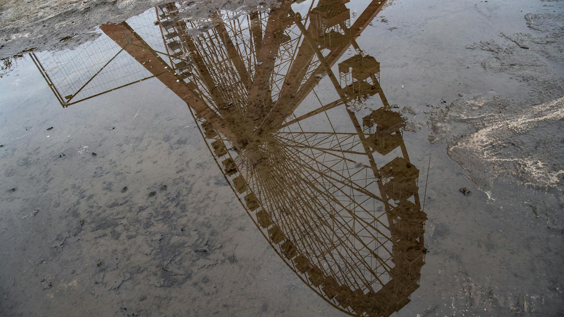 Das Riesenrad im Spreepark spiegelt sich in einer Pfütze. Die Sanierungsarbeiten des historischen Fahrgeschäftes haben begonnen. 
