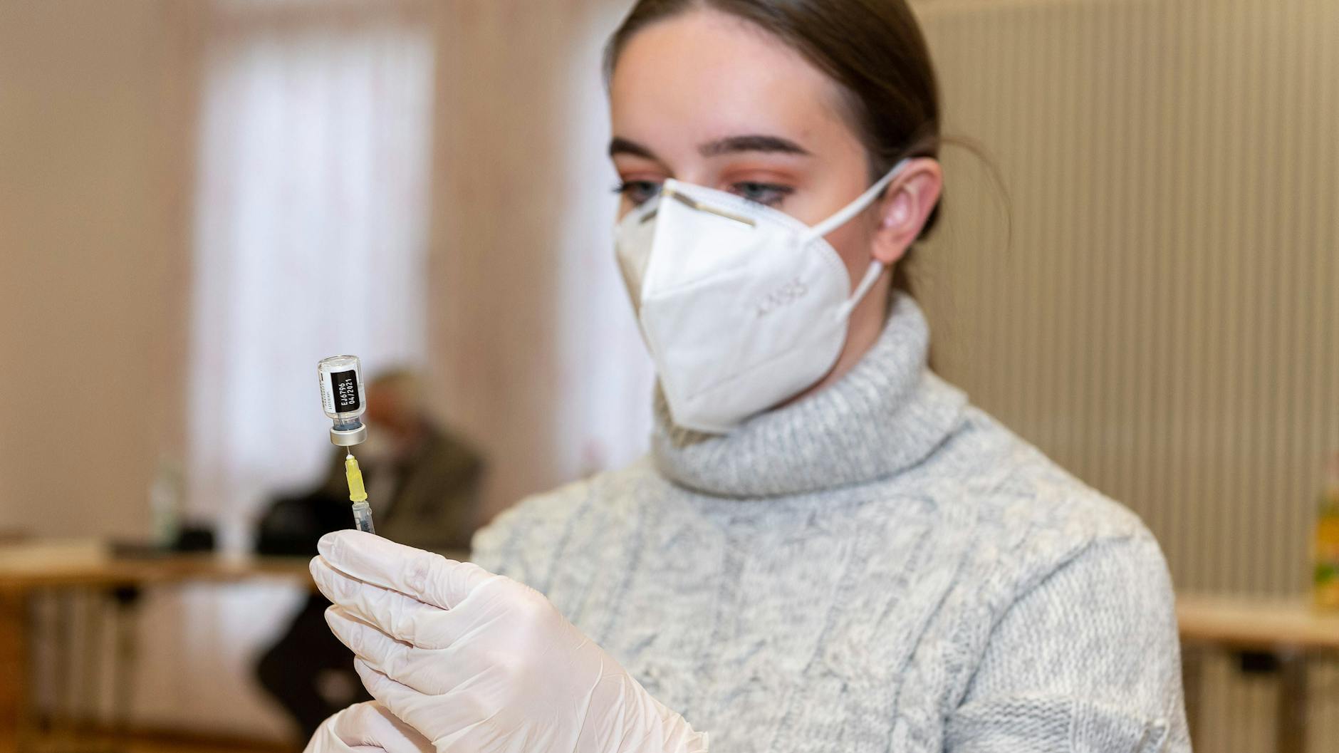Eine Krankenschwester eines Pflegheimes des Deutschen Roten Kreuzes füllt Corona-Impfstoff in eine Spritze (Symbolbild).