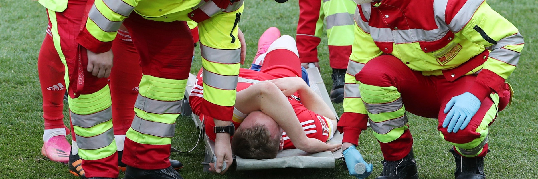 Mit schmerzverzerrtem Gesicht wird Cedrik Teuchert verletzt auf einer Trage liegend aus dem Stadion gebracht. <br>