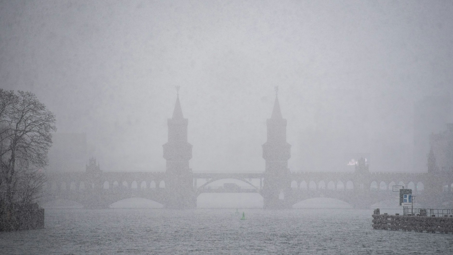 Die Oberbaumbrücke über der Spree ist im Schneegestöber kaum noch zu erkennen.