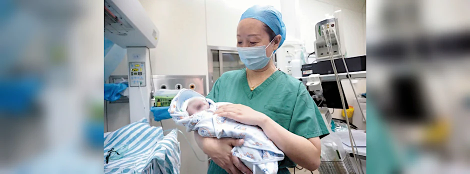 Ein Mediziner im&nbsp;Maternal and Child Health Hospital in Hubei hält den jüngeren Zwilling im Arm.
