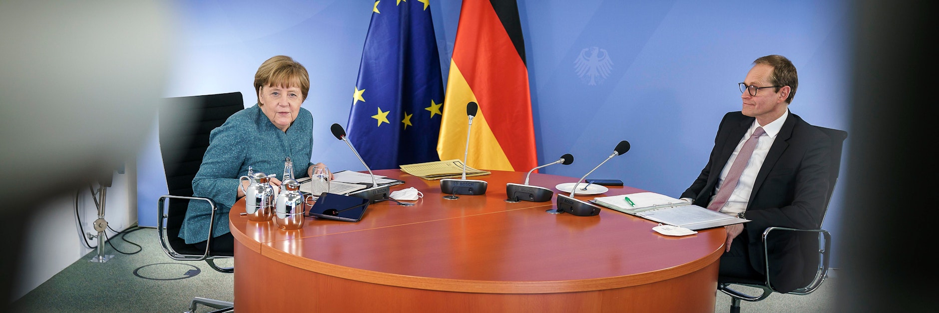 Angela Merkel und der Regierende Bürgermeister Michael Müller an ihrem „Stammtisch“ im Kanzleramt, an dem sie bei den Videokonferenzen immer sitzen.