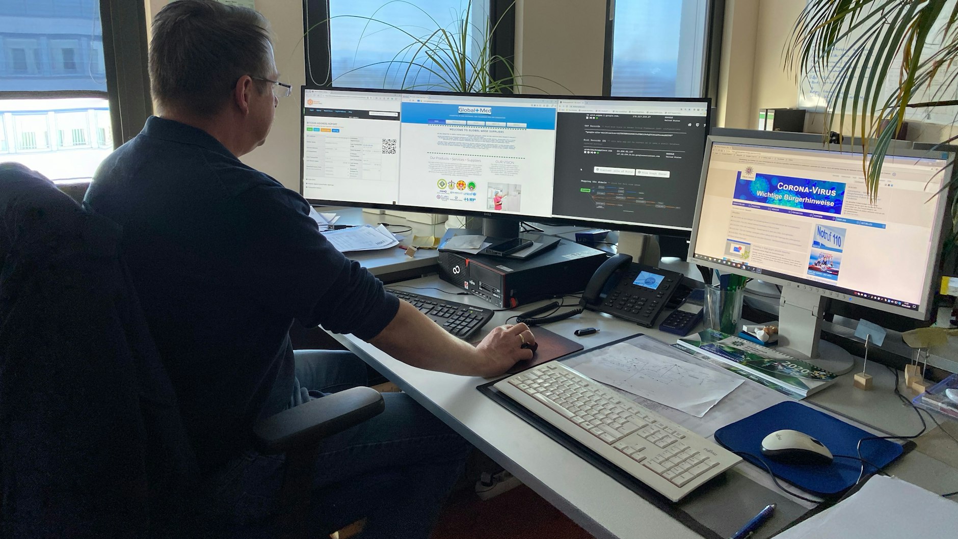 Kriminalhauptkommissar Frank Peter aus dem Zentralkommissariat für Internetkriminalität im Polizeipräsidium Osthessen (Fulda) sitzt in seinem Büro vor mehreren Bildschirmen.