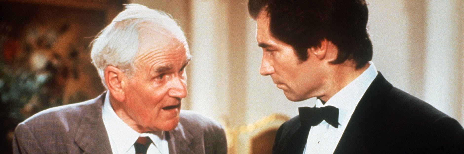 Timothy Dalton (r.) als James Bond im Gespräch mit Desmond Llewelyn als Geheimwaffenerfinder „Q“ in einer Filmszene.