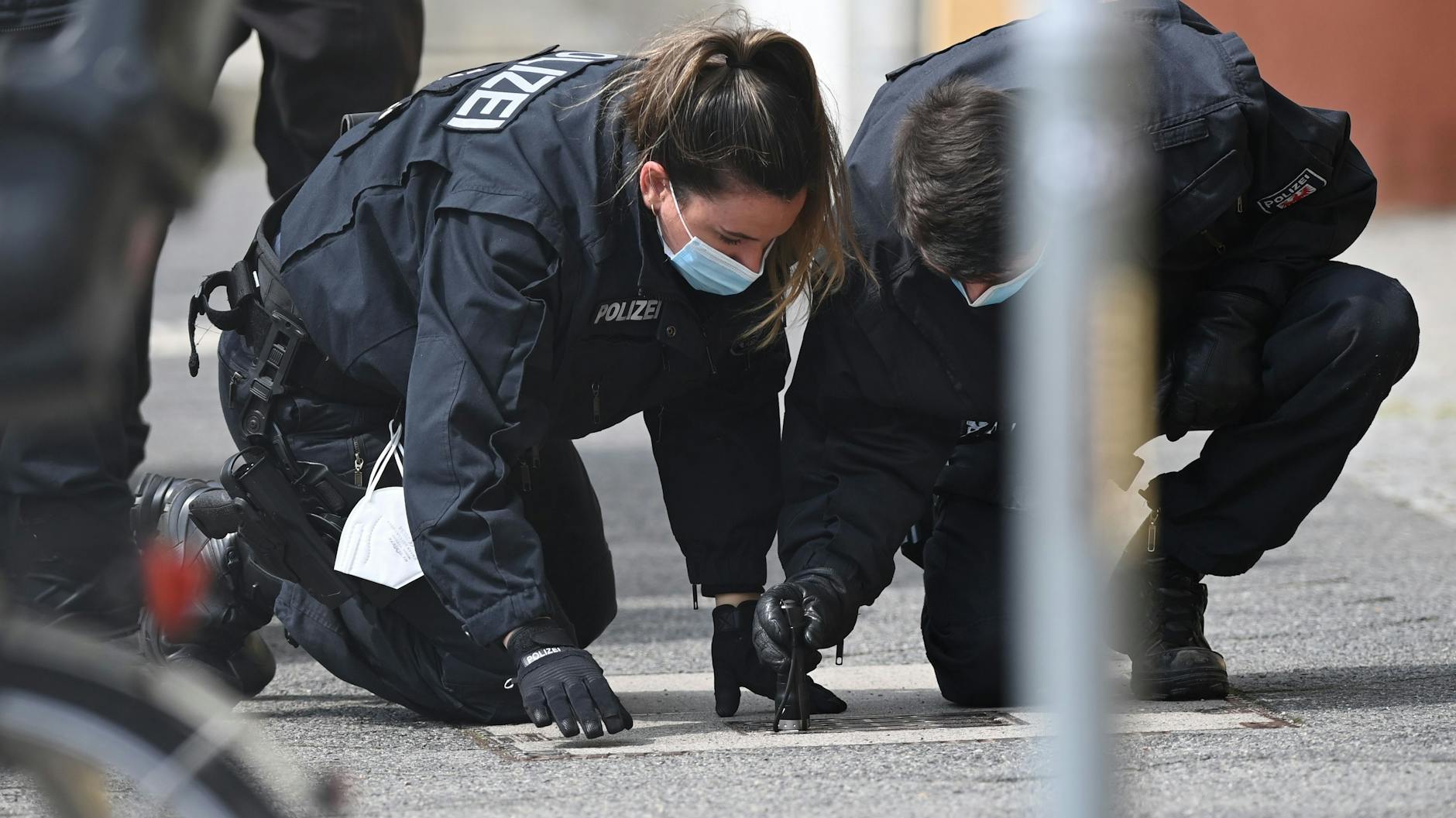 Polizisten suchen auf dem Fußweg und neben den Gebäuden des diakonischen Anbieters Oberlinhaus nach Spuren.