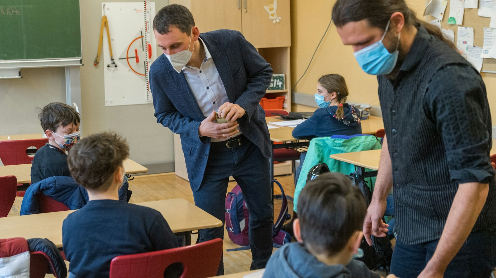 Ein Klassenlehrer in Halle (Saale) überprüft einen vor Ort durchgeführten Selbsttest. Auch Sachsen-Anhalt gehört zu den Bundesländern mit Testpflicht für Schülerinnen und Schüler.