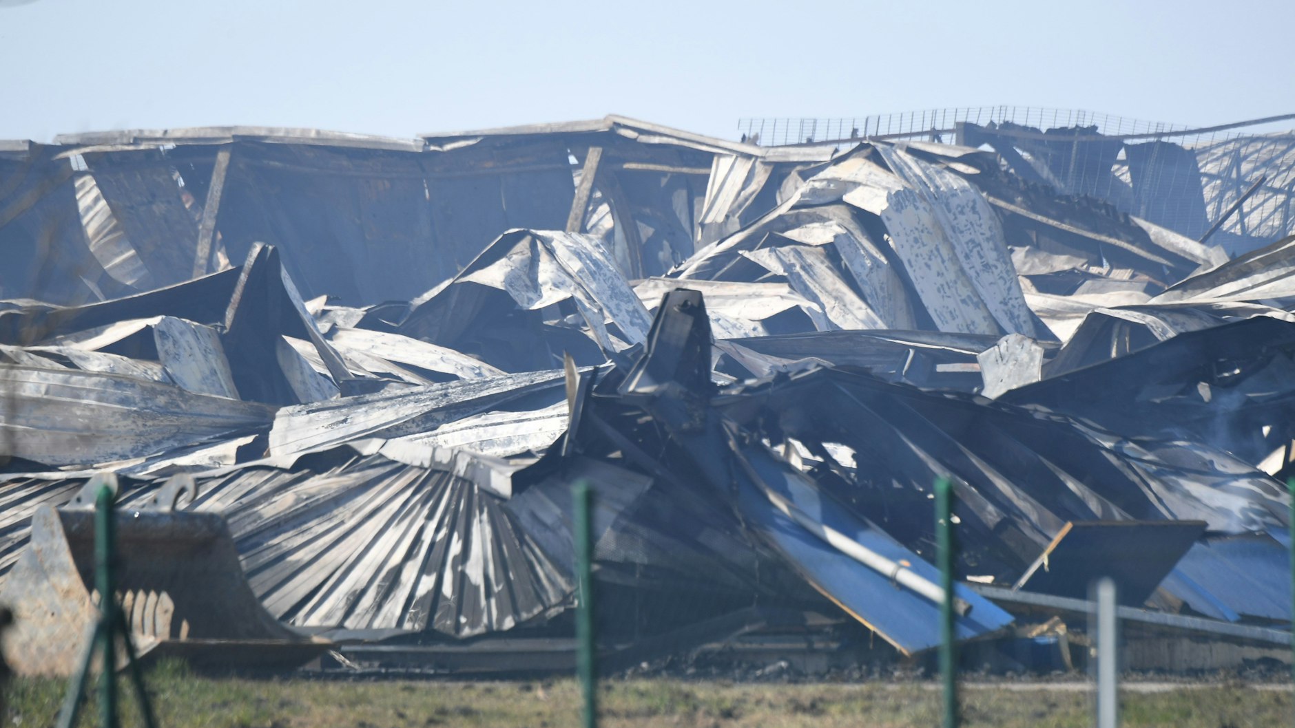 Die Dachkonstruktion eines Gebäudes des Schweinemastbetriebes liegt nach dem Feuer in Trümmern.