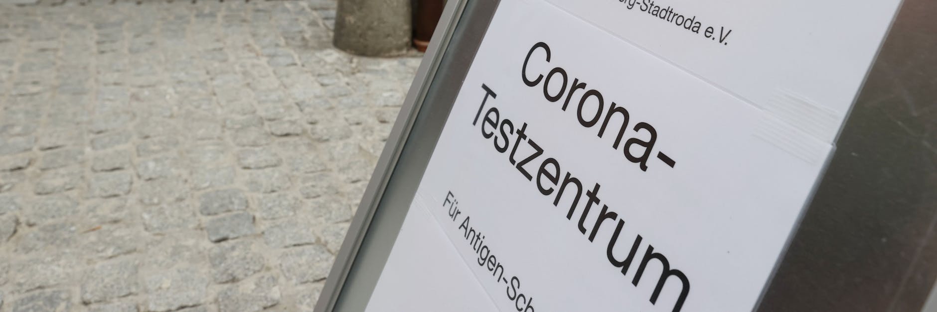 Ein Hinweisschild zum Corona Schnelltest steht vor dem DRK Centrum in der Innenstadt.