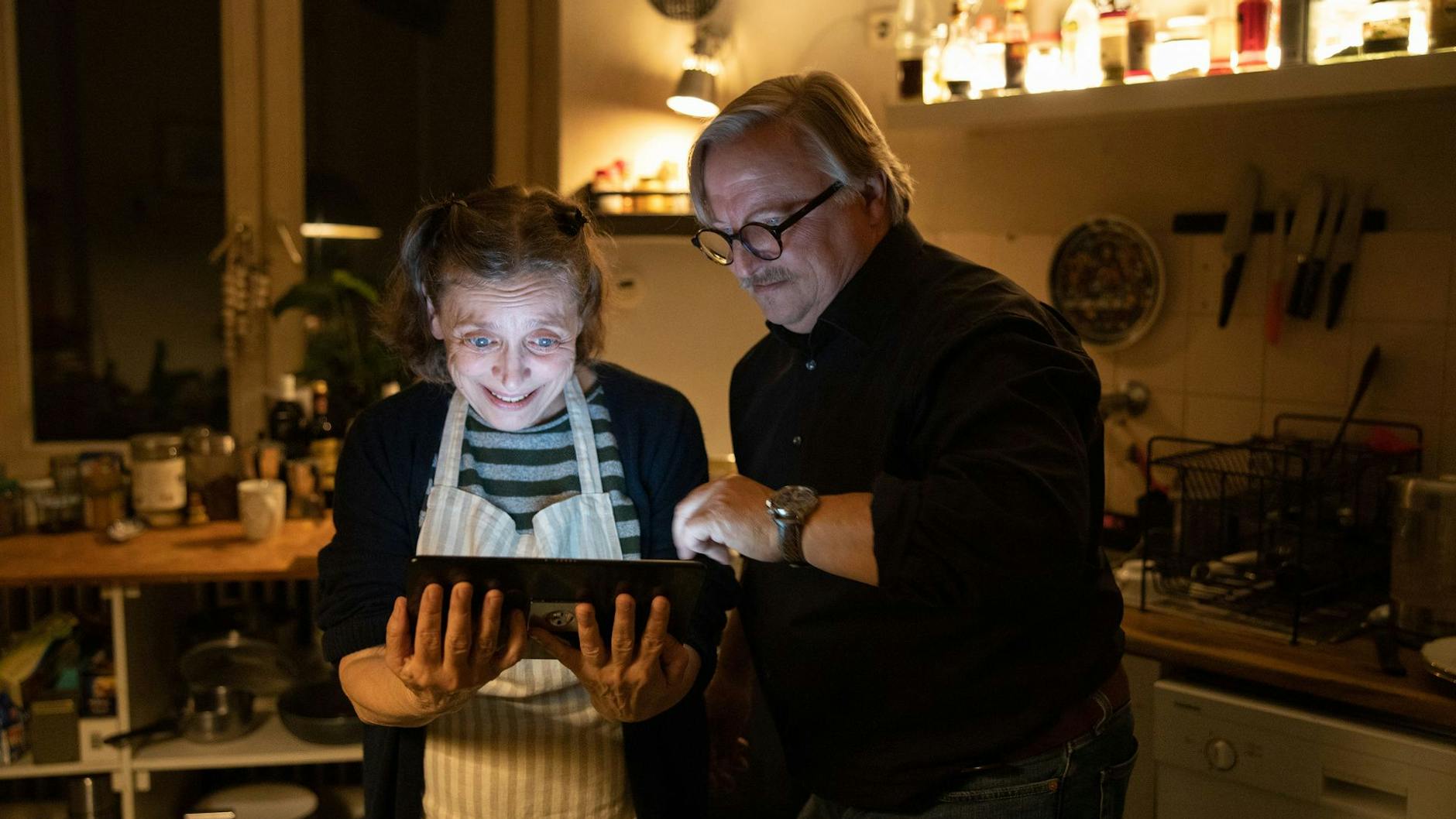 Ralph Friesner (Axel Prahl, r.) überrascht seine Mitbewohnerin Karin (Katharina Thalbach, l.) mit einem Tablet. Endlich kann sie mit ihrem Enkel sprechen!