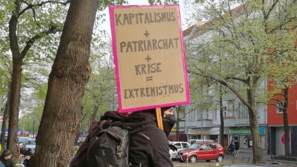 Demonstranten drücken ihre politische Kritik mit einer Gleichung aus. Am Ende kommt „Extremistmus“ heraus. 