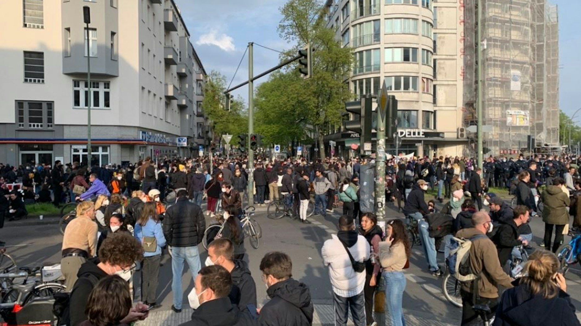 1. Mai in Berlin: Am Neuköllner Hermannplatz stehen junge Leute in der Abendsonne.