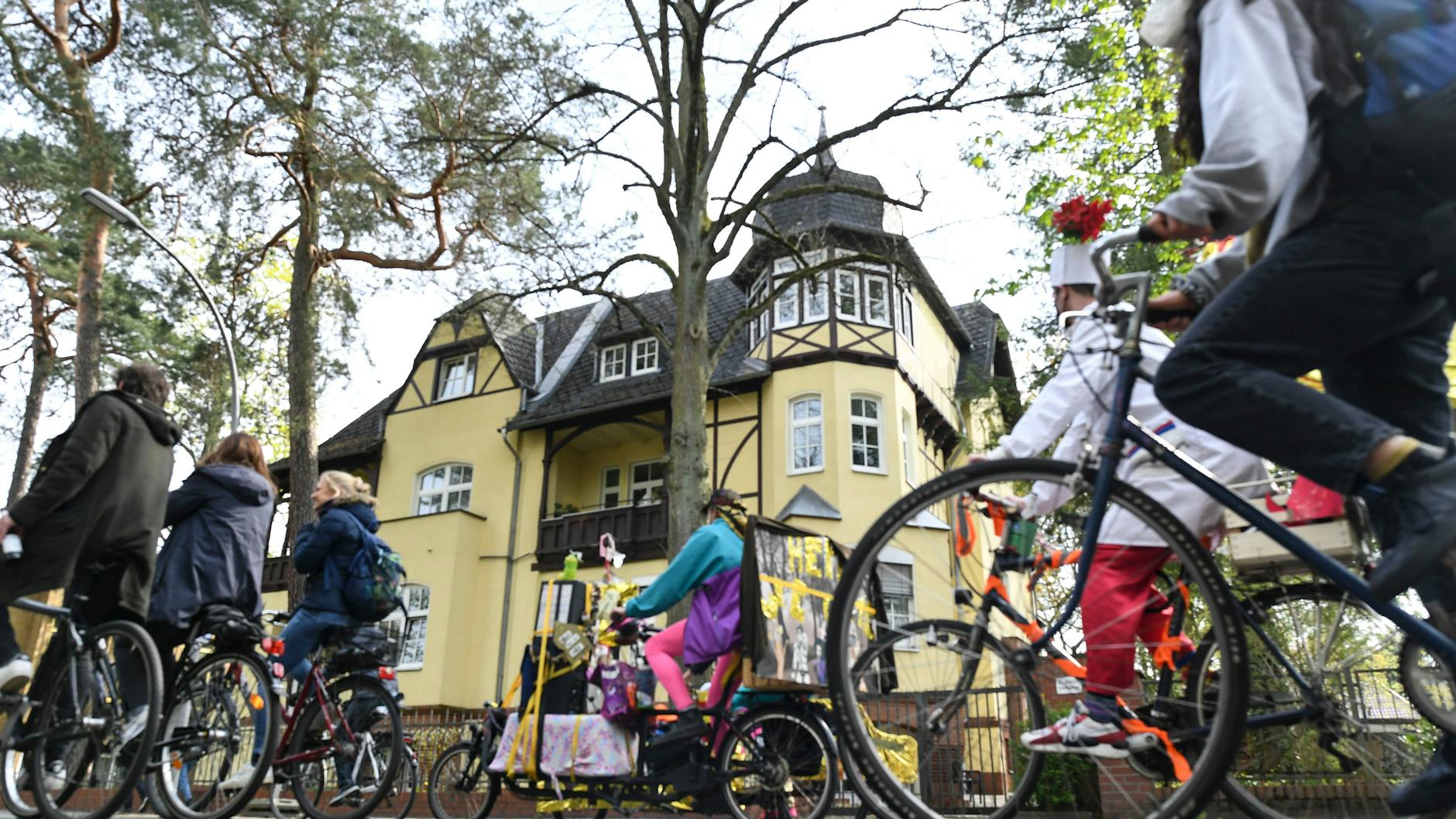 Demonstrators cycle past a Grunewald mansion.