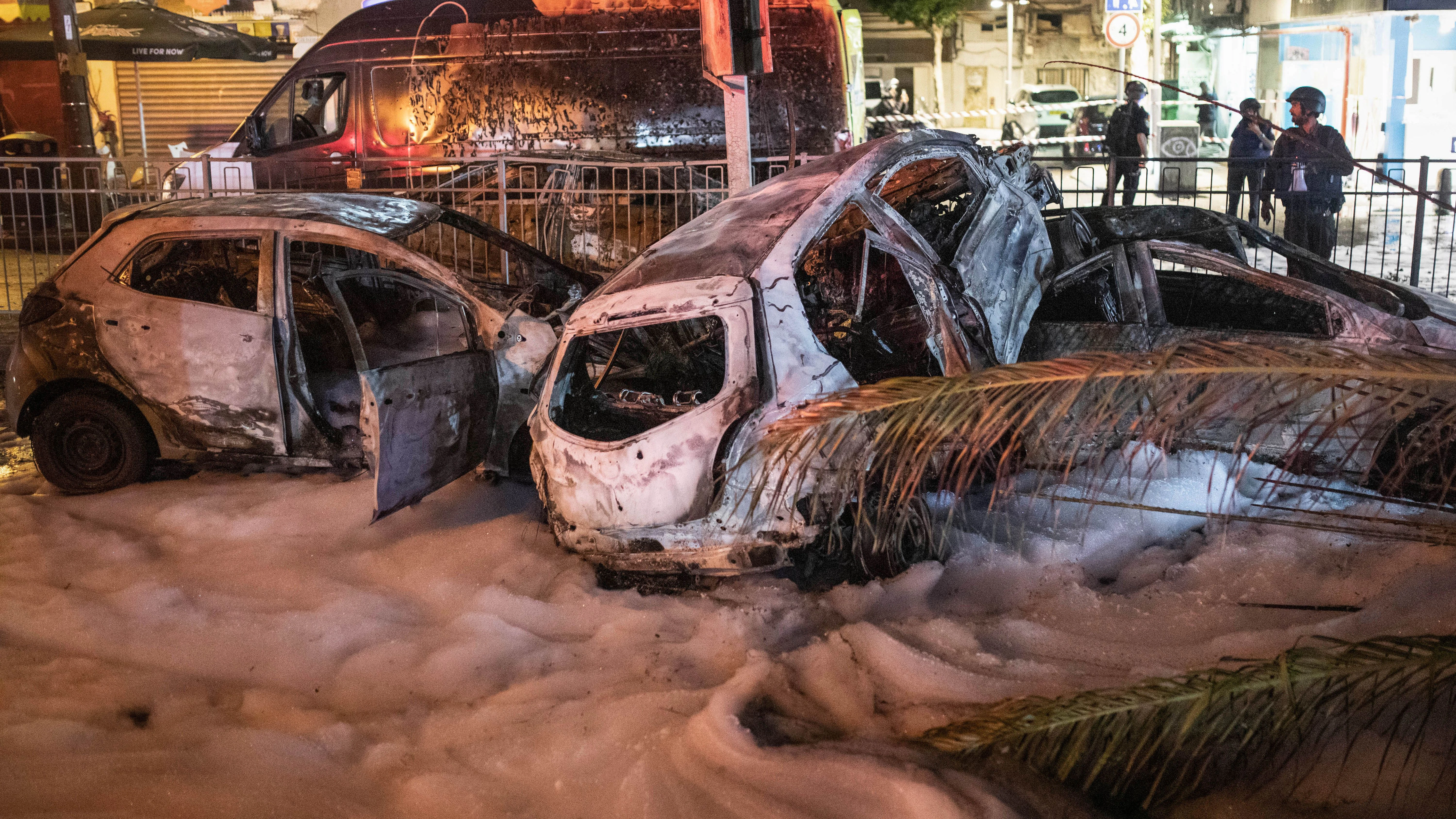 Schäden in der israelischen Stadt Holon: Mehrere verbrannte Fahrzeuge sind mit Löschschaum bedeckt. Die Fahrzeuge wurden von einer Rakete getroffen, die aus dem Gazastreifen in Richtung Israel abgefeuert wurde.