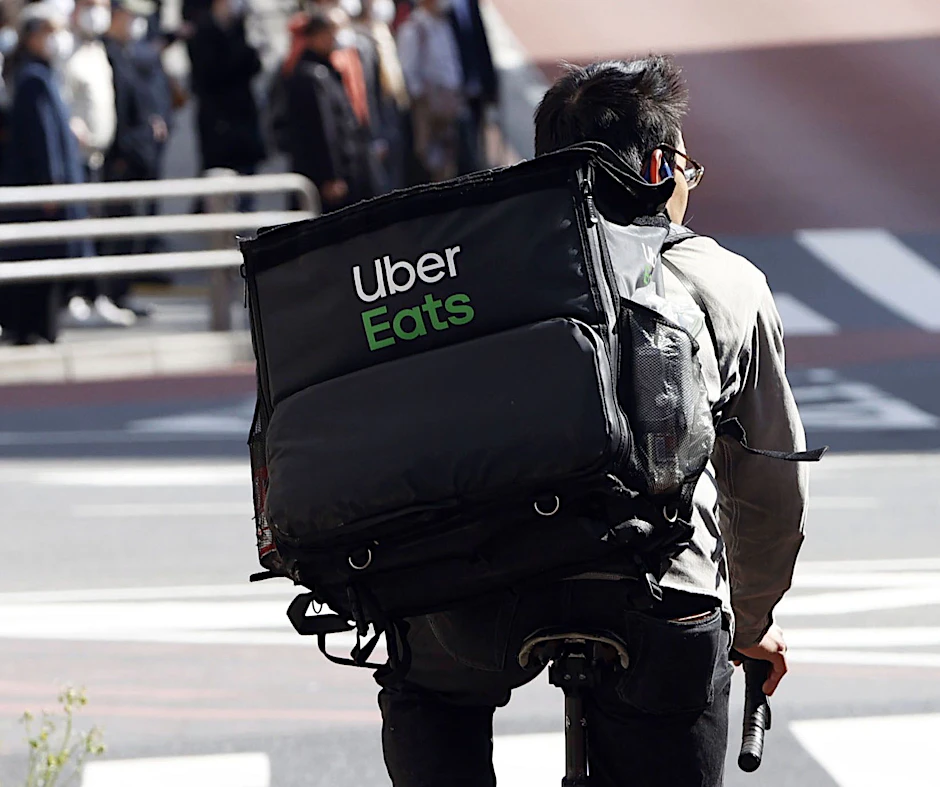 Ein Mitarbeiter von Uber Eats radelt mit einer Lieferung durch die Stadt (Symbolbild).