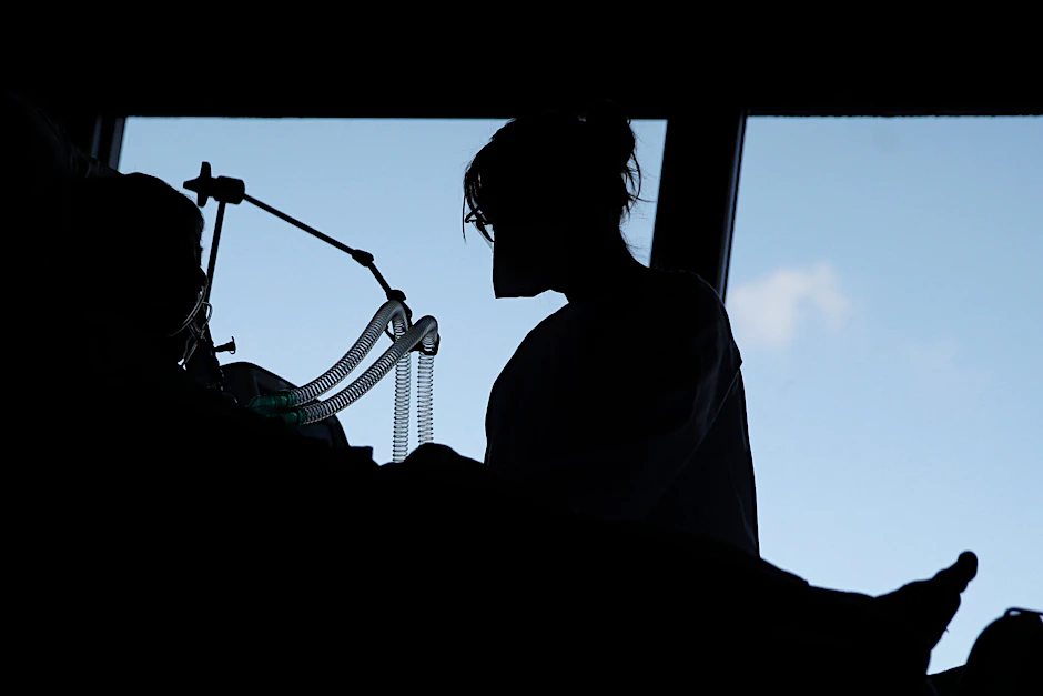 Ein Corona-Patient und eine Pflegekraft auf einer Intensivstation.