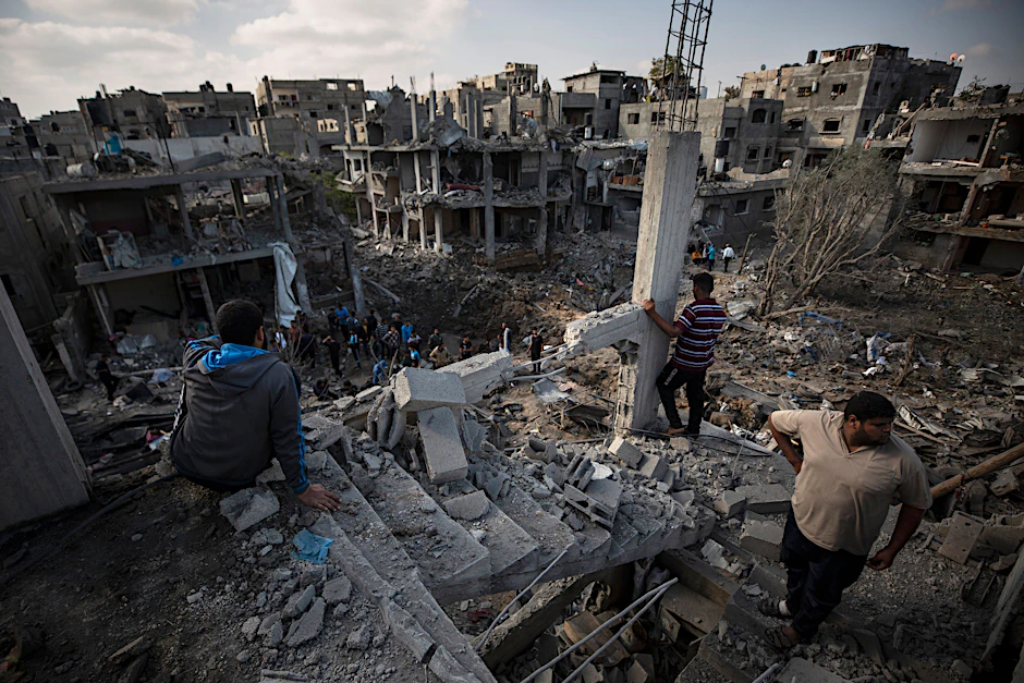 Palästinenser stehen in den Trümmern ihrer Wohnhäuser im Gazastreifen.
