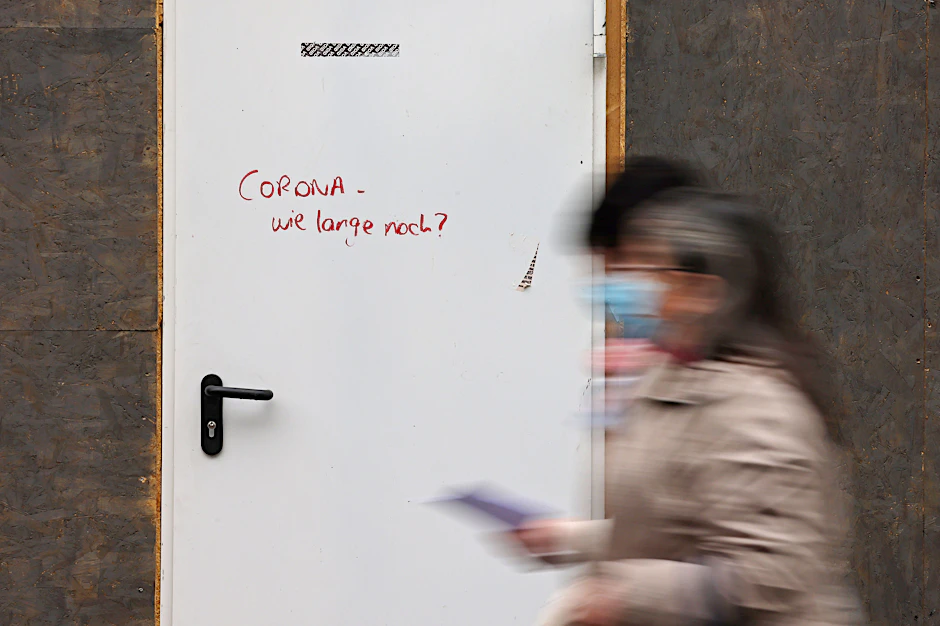 Auf der Tür eines geschlossenen Ladenlokals steht der Schriftzug "Corona - wie lange noch". Der Corona-Wochenwert ist deutschlandweit rückläufig.
