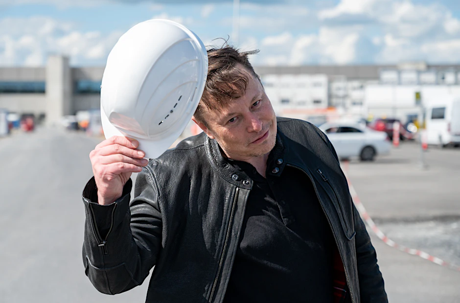 Tesla-Chef Elon Musk steht auf der Baustelle in Grünheide und grüßt mit einem Schutzhelm. Er hat sich am Montag ein Bild vom Baufortschritt der neuen Gigafactory gemacht.&nbsp;