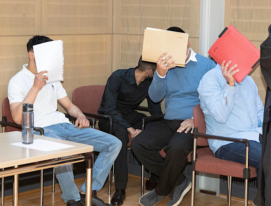 Vor Gericht versteckten sich die mutmaßlichen Räuber hinter Aktendeckeln.