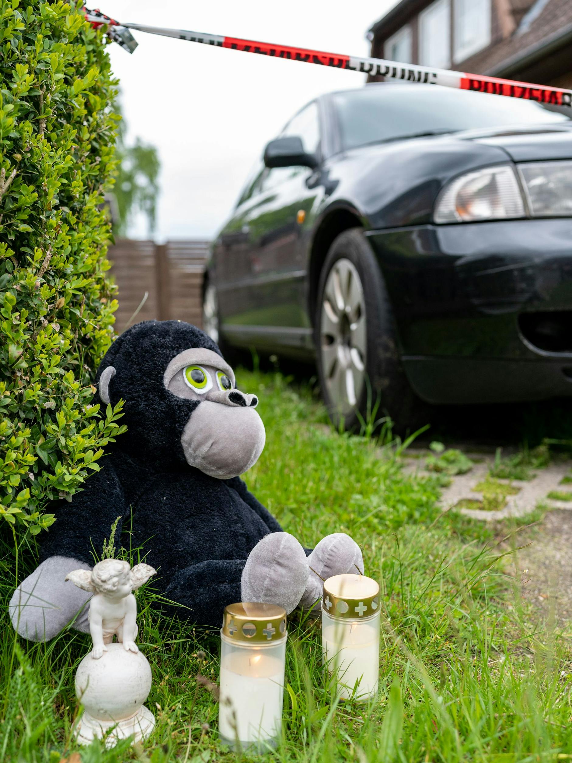 Kerzen, ein Engel und ein Kuscheltier stehen vor dem Wohnhaus in Bispingen.
