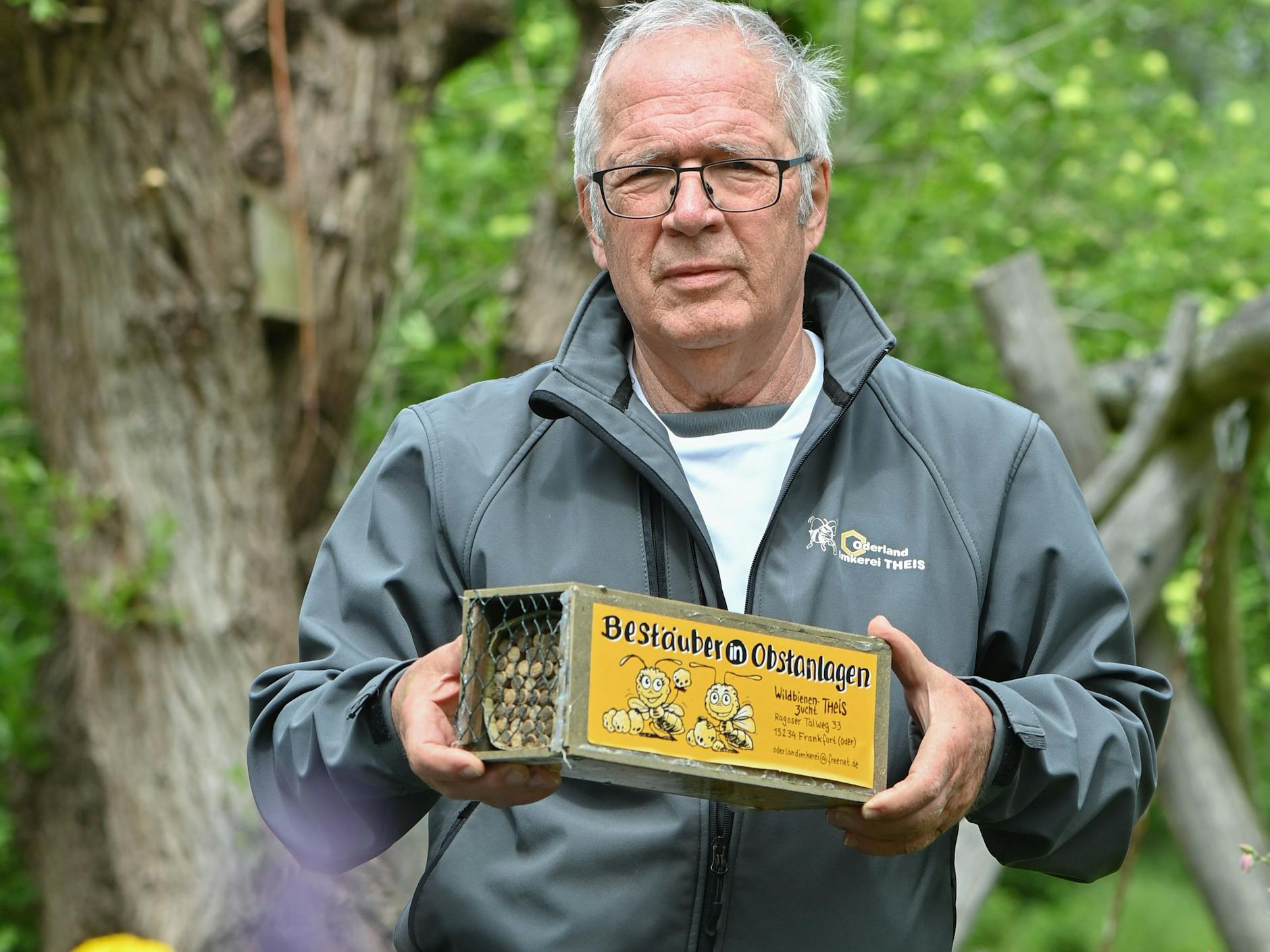 Eberhard Theis, Hobby-Imker, zeigt in seinem Garten eine kleine Kiste mit speziellen Brutröhrchen für die Gehörnte Mauerbiene.