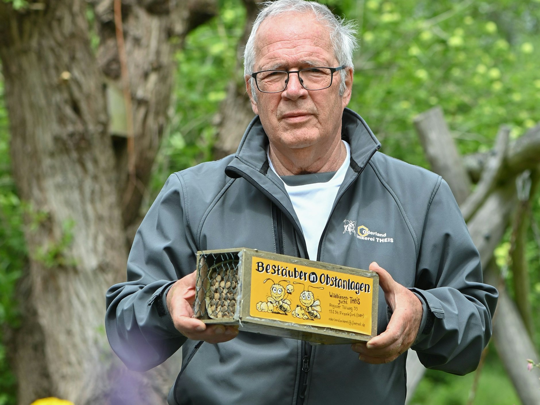 Eberhard Theis, Hobby-Imker, zeigt in seinem Garten eine kleine Kiste mit speziellen Brutröhrchen für die Gehörnte Mauerbiene.
