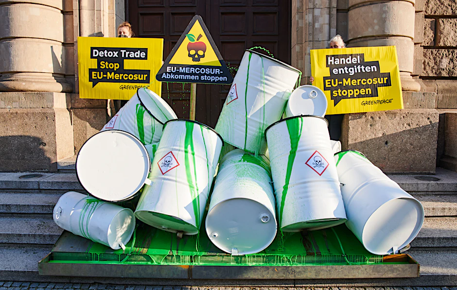 Fässer, die symbolisch als Giftfässer mit grüner Farbe angemalt wurden, stehen bei einer Greenpeace-Aktion vor dem Wirtschaftsministerium in Berlin.